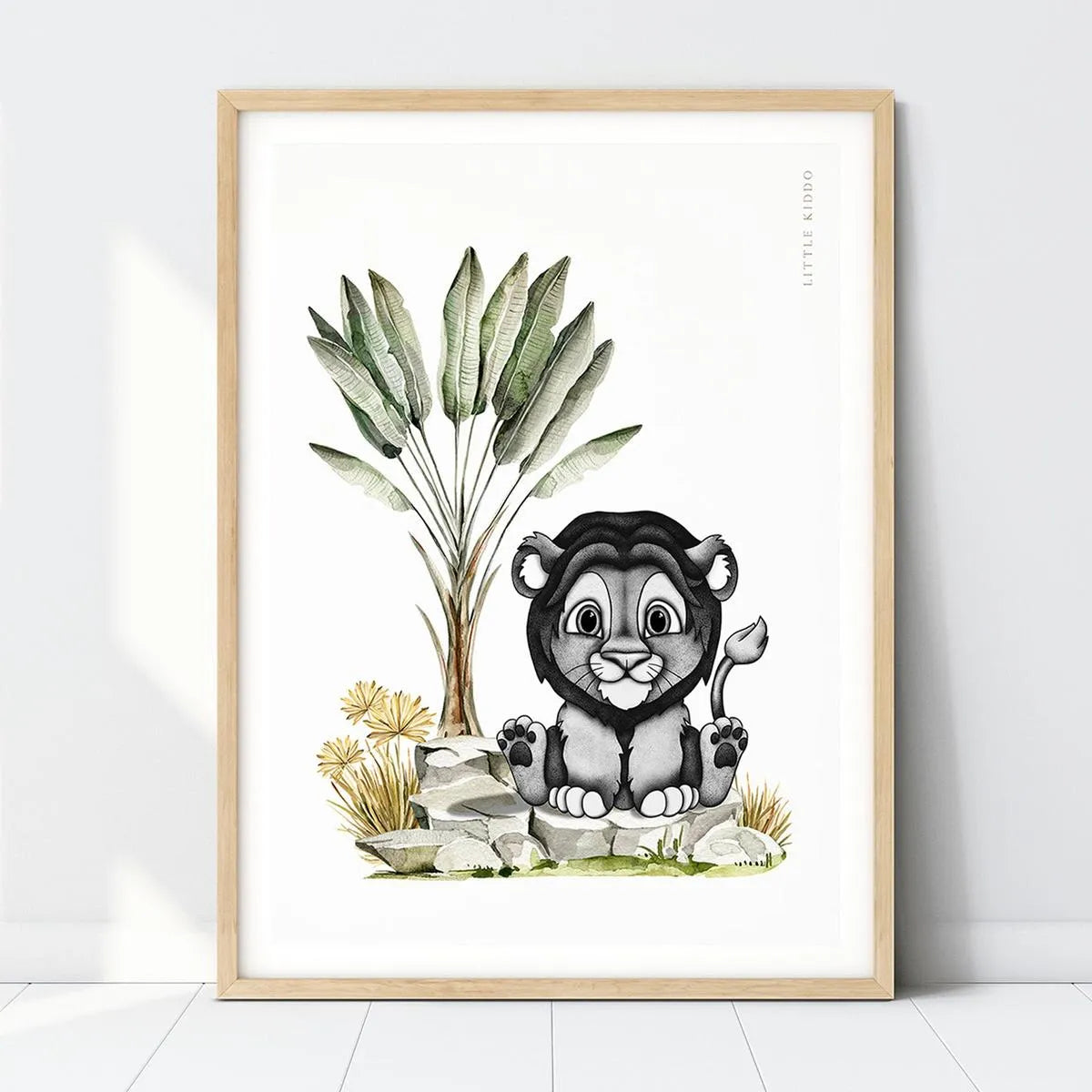Baby lion nursery art print featuring a hand-drawn lion cub under a banana palm in a light wood frame, safari animal wall decor.
