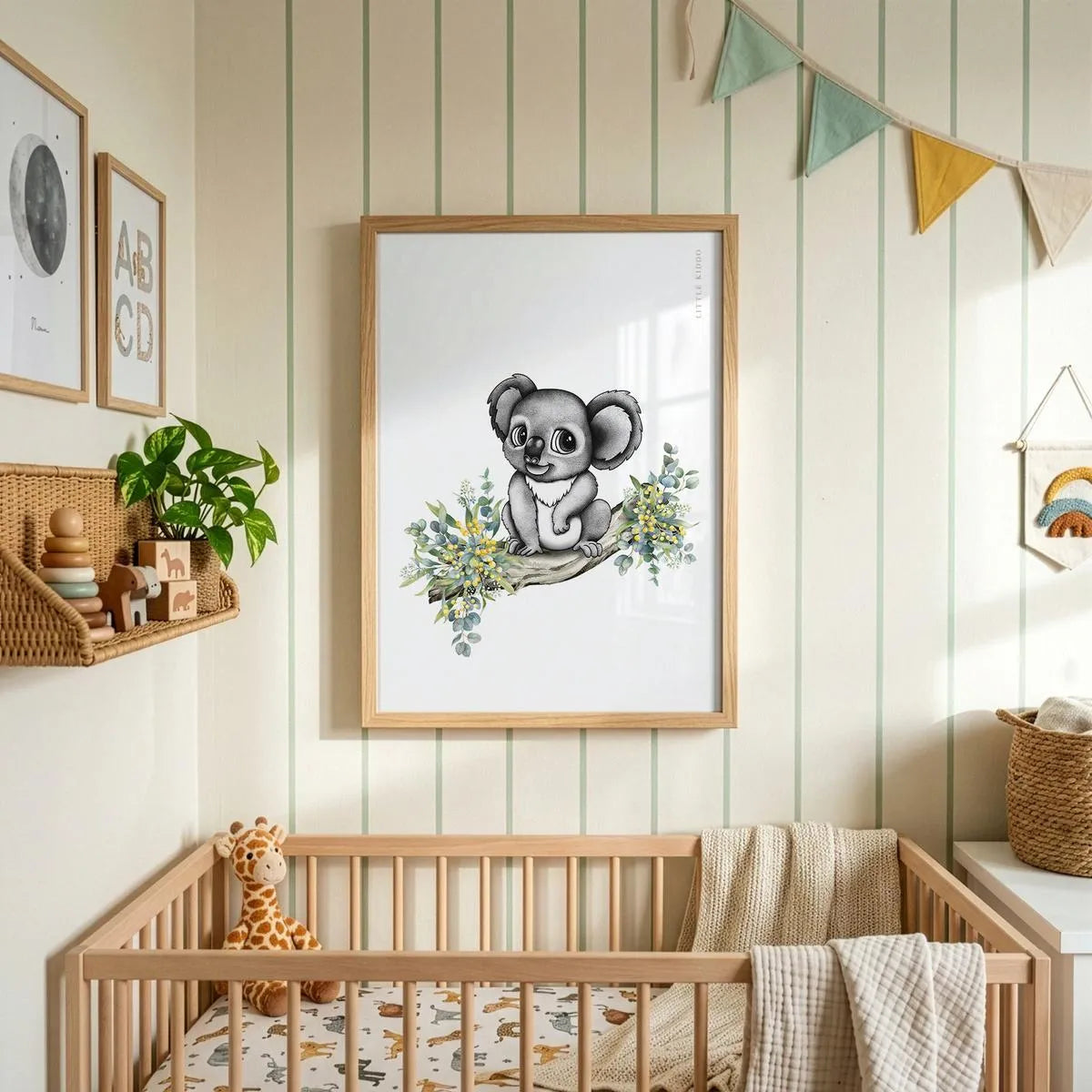 Minimalist baby koala art hanging above a wooden crib in a nursery with striped wallpaper and colorful fabric bunting.