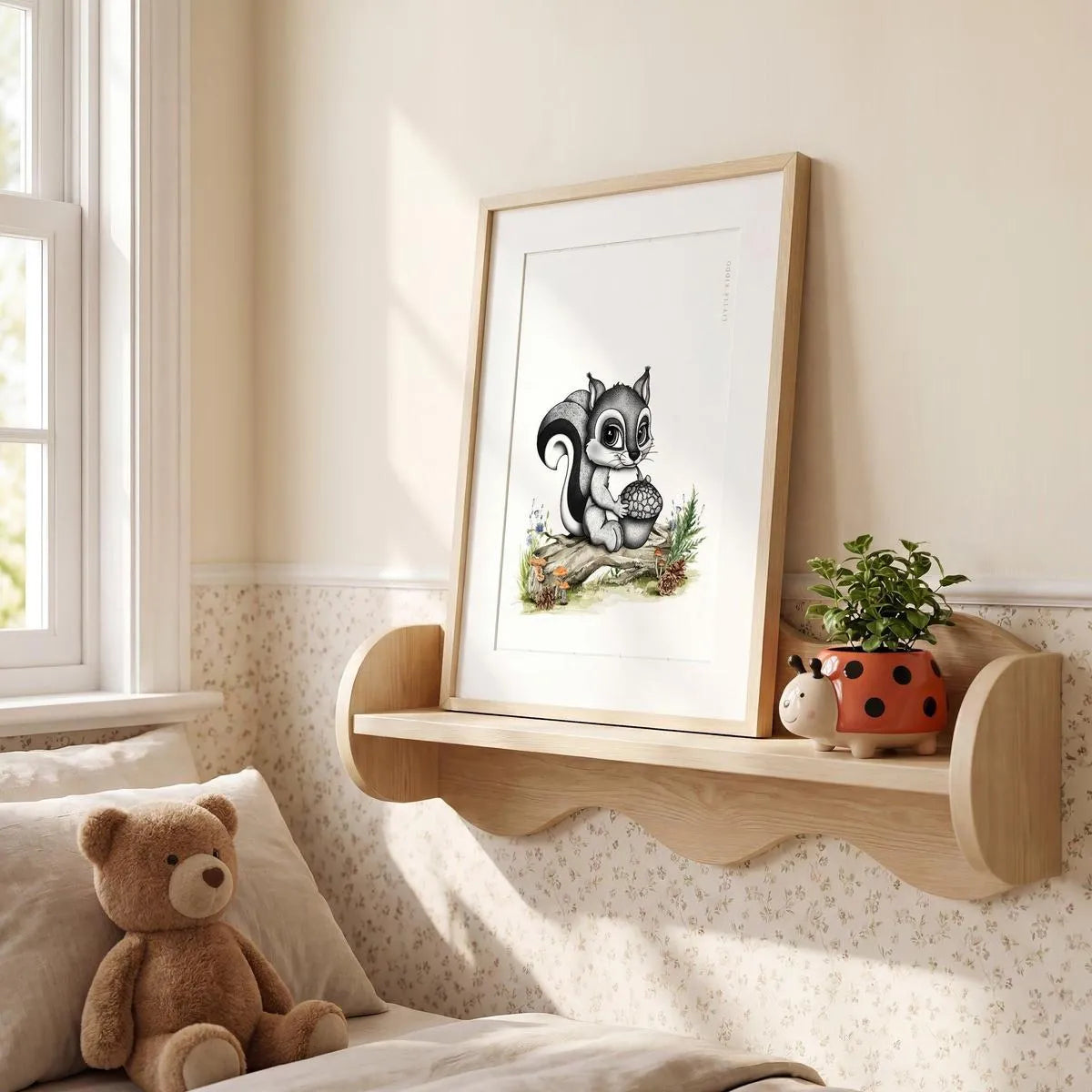 Framed squirrel illustration sitting on a wooden nursery shelf, cute forest-themed bedroom decor and nursery styling ideas.