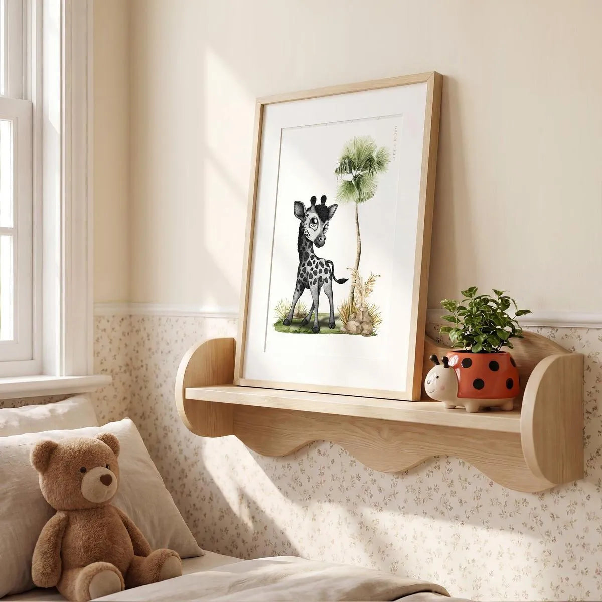 Minimalist giraffe nursery illustration in an oak frame sitting on a wooden wall shelf, cute safari-themed bedroom decor.