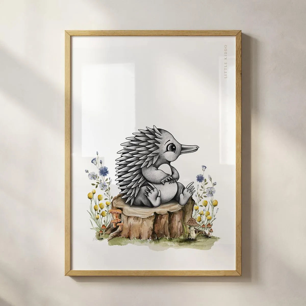 Minimalist baby echidna art print in a light wood frame, artisanal Australian wildlife wall hanging for a nature-themed baby room.