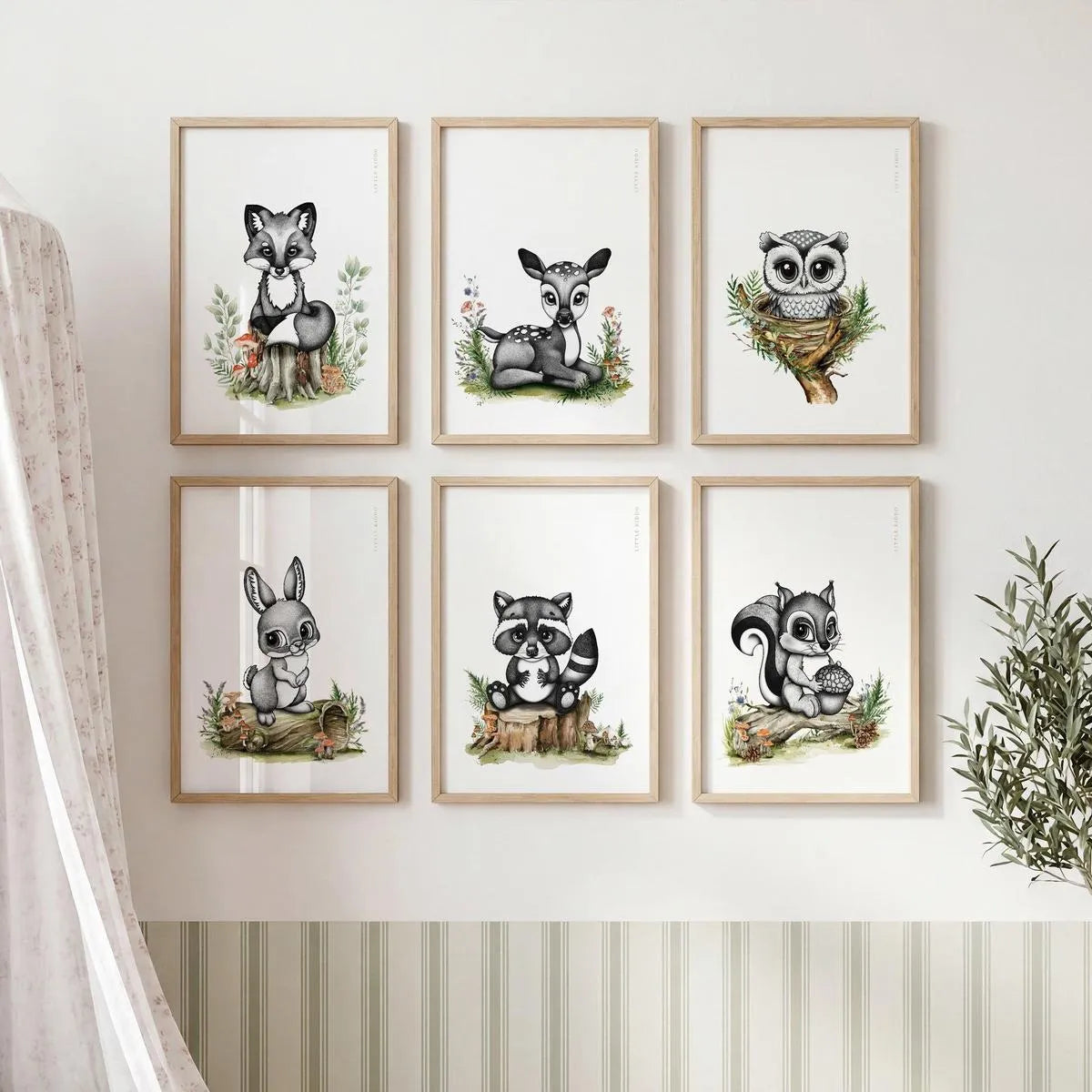Gallery wall set of 6 woodland nursery prints including a deer, fox, owl, bunny-rabbit, raccoon, and squirrel in matching oak frames.
