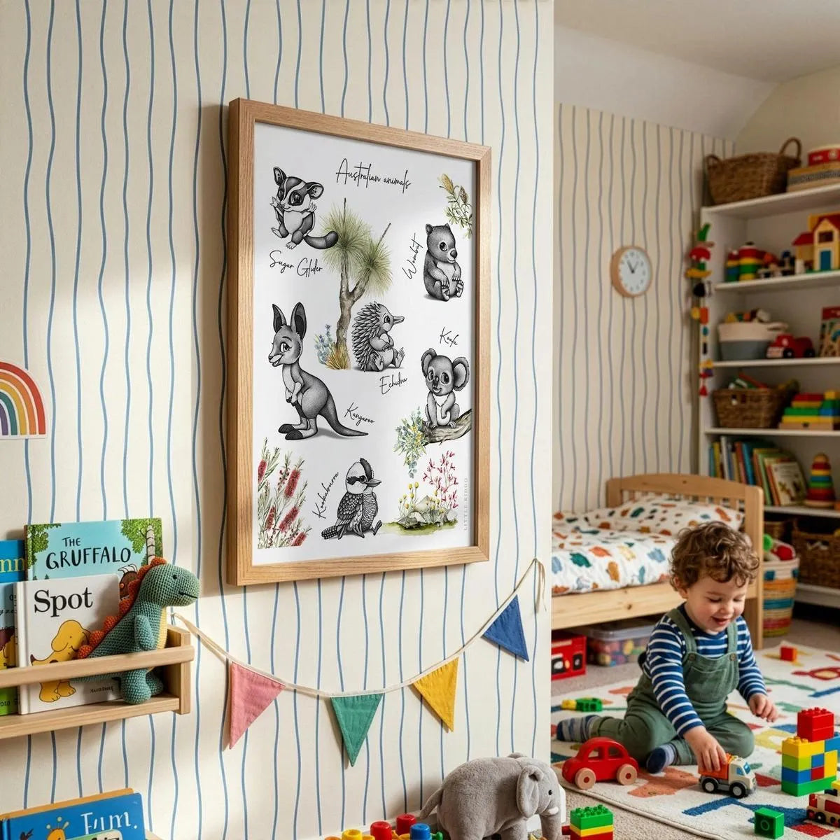 Large Australian animal alphabet-style print on striped wallpaper in a bright, modern playroom with colorful bunting.