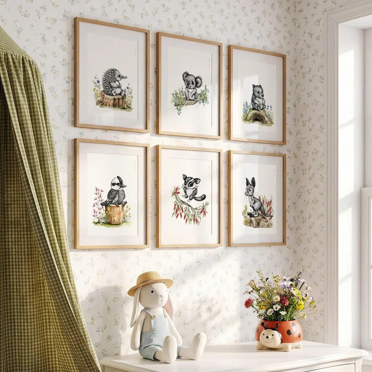 A curated 6-piece gallery wall set of Australian animal nursery prints in oak frames, featuring a Koala, Wombat, Kangaroo, Kookaburra, Echidna and Sugar Glider.