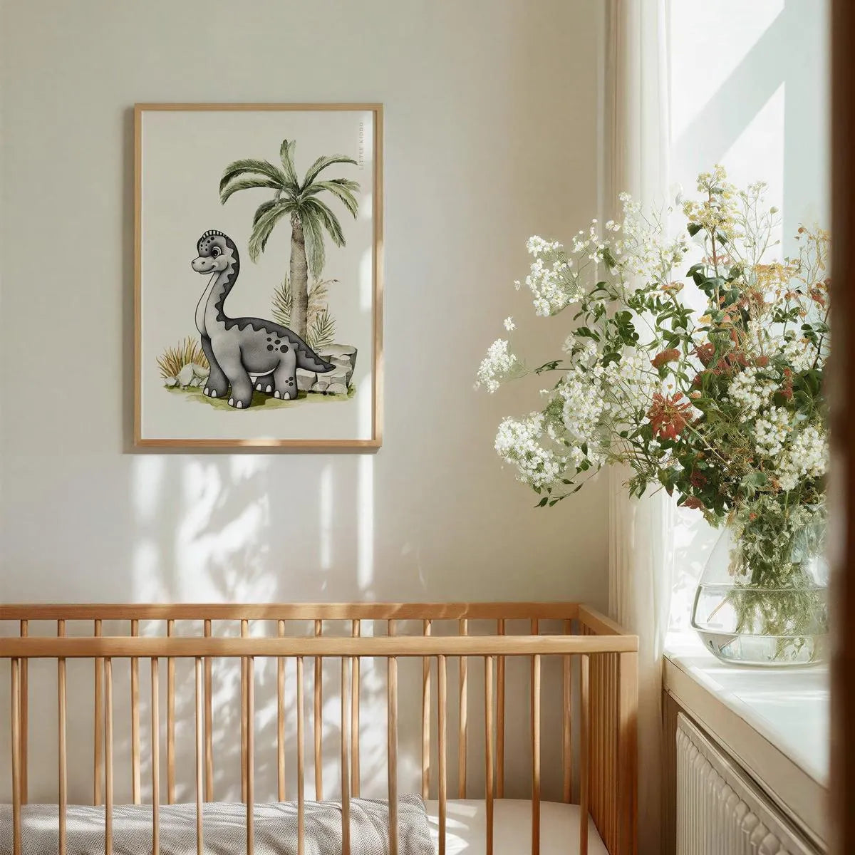 Whimsical Brachiosaurus nursery wall art hanging above a wooden baby crib, styled with fresh white flowers and neutral decor.