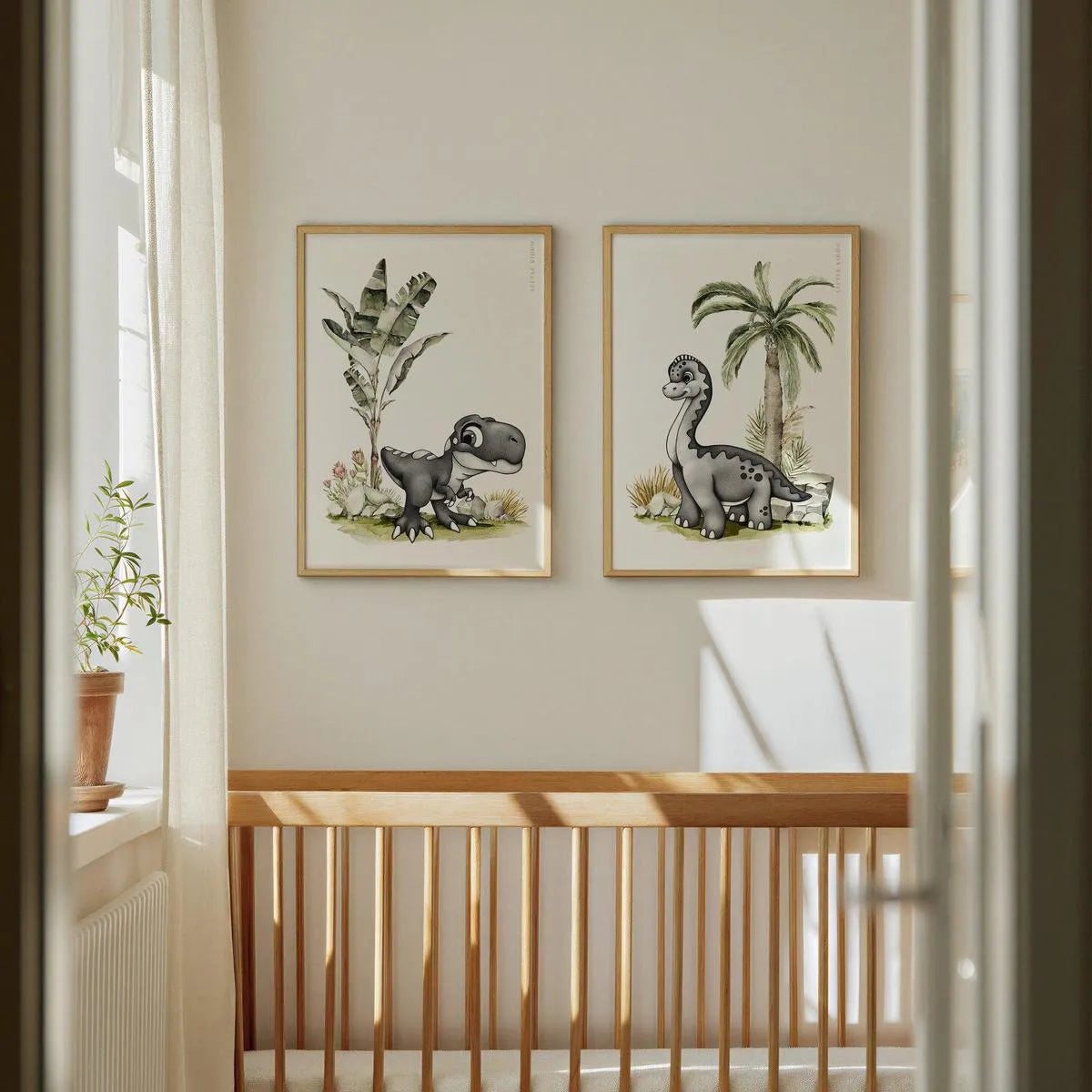 Pair of hand-drawn dinosaur nursery art prints featuring a baby T-Rex and Brachiosaurus in oak frames, hanging above a light wood baby crib in a minimalist, sun-drenched nursery.