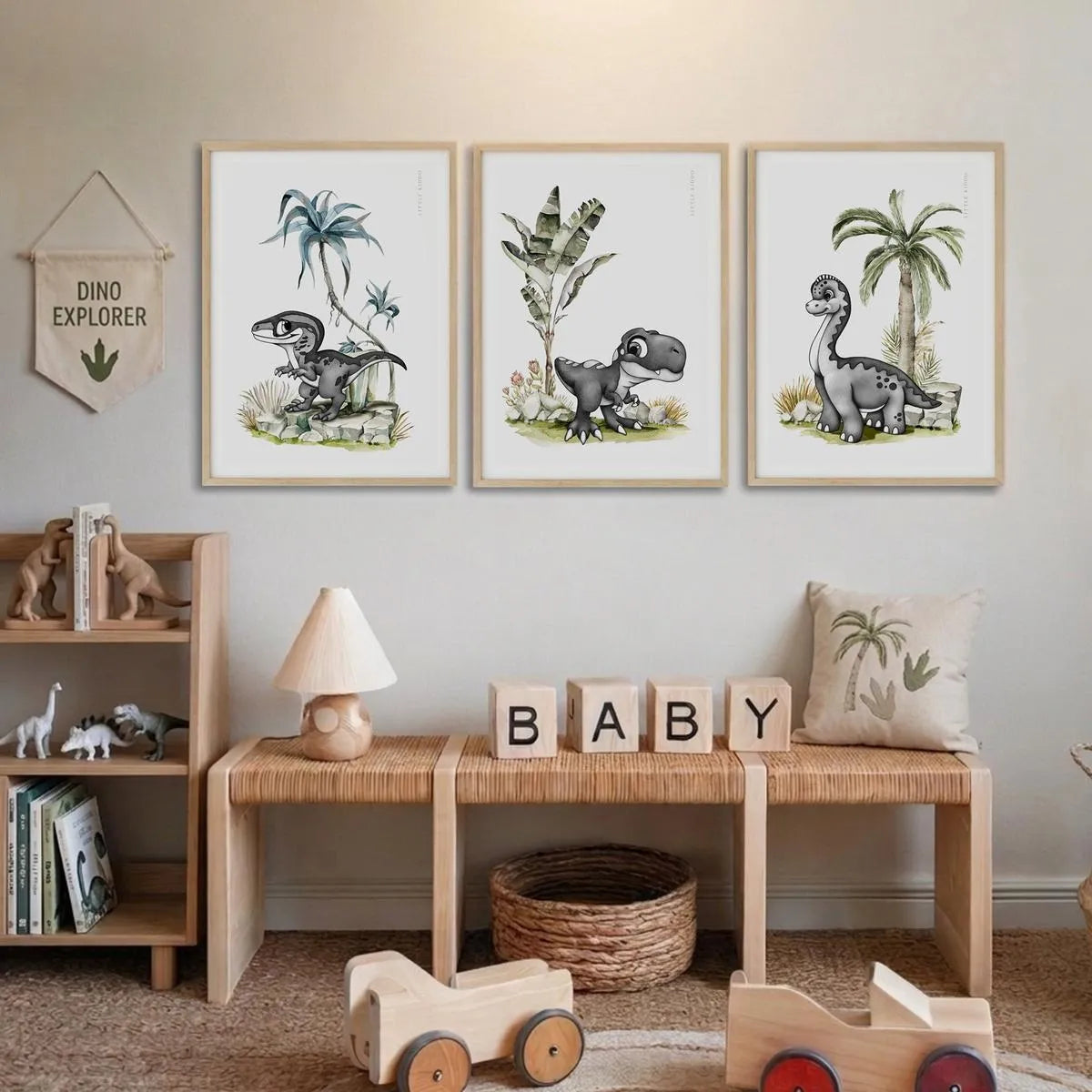 Set of 3 dinosaur nursery prints featuring a Pterodactyl, Velociraptor, and Brachiosaurus styled above a wooden bench in a neutral playroom.