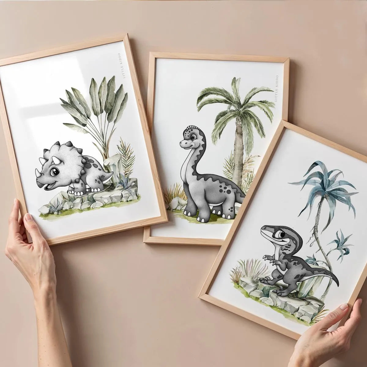 A curated collection of three dinosaur-themed prints including a Triceratops, Brachiosaurus, and Velociraptor in oak frames.