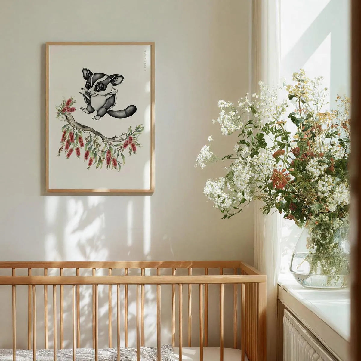 Whimsical sugar glider wall art hanging above a wooden baby crib, gender-neutral Australian bush animal decor in a bright nursery.