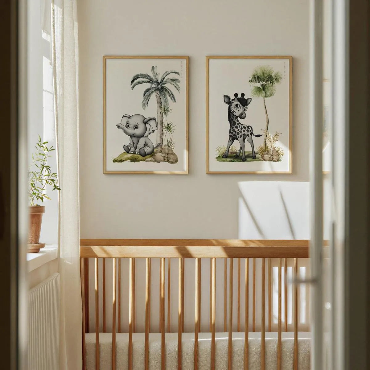 Set of 2 safari nursery prints featuring an elephant and a giraffe hanging above a wooden crib in a minimalist baby room.