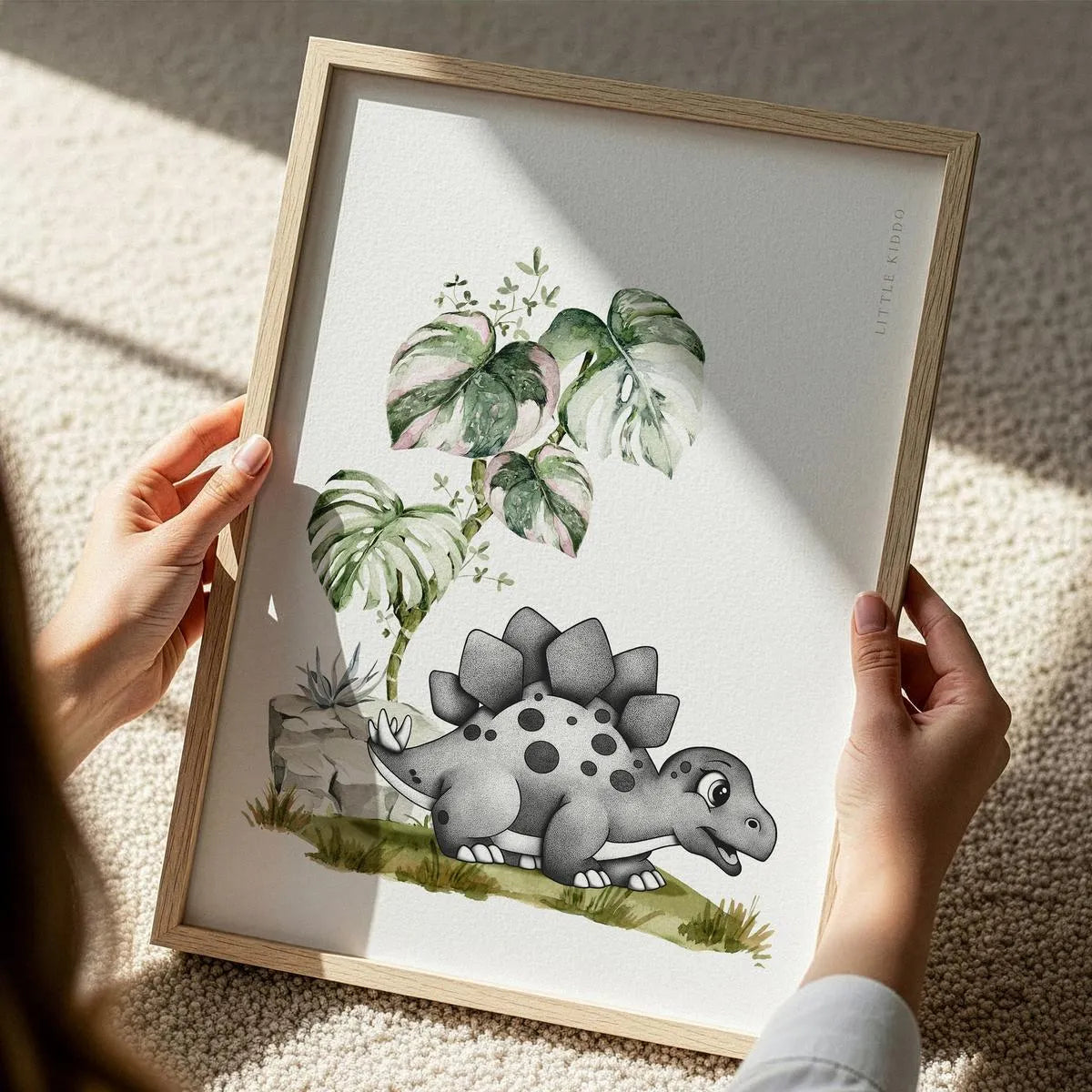 Close-up of a hand-inked Stegosaurus illustration for kids, featuring detailed stippling and green botanical watercolor accents.