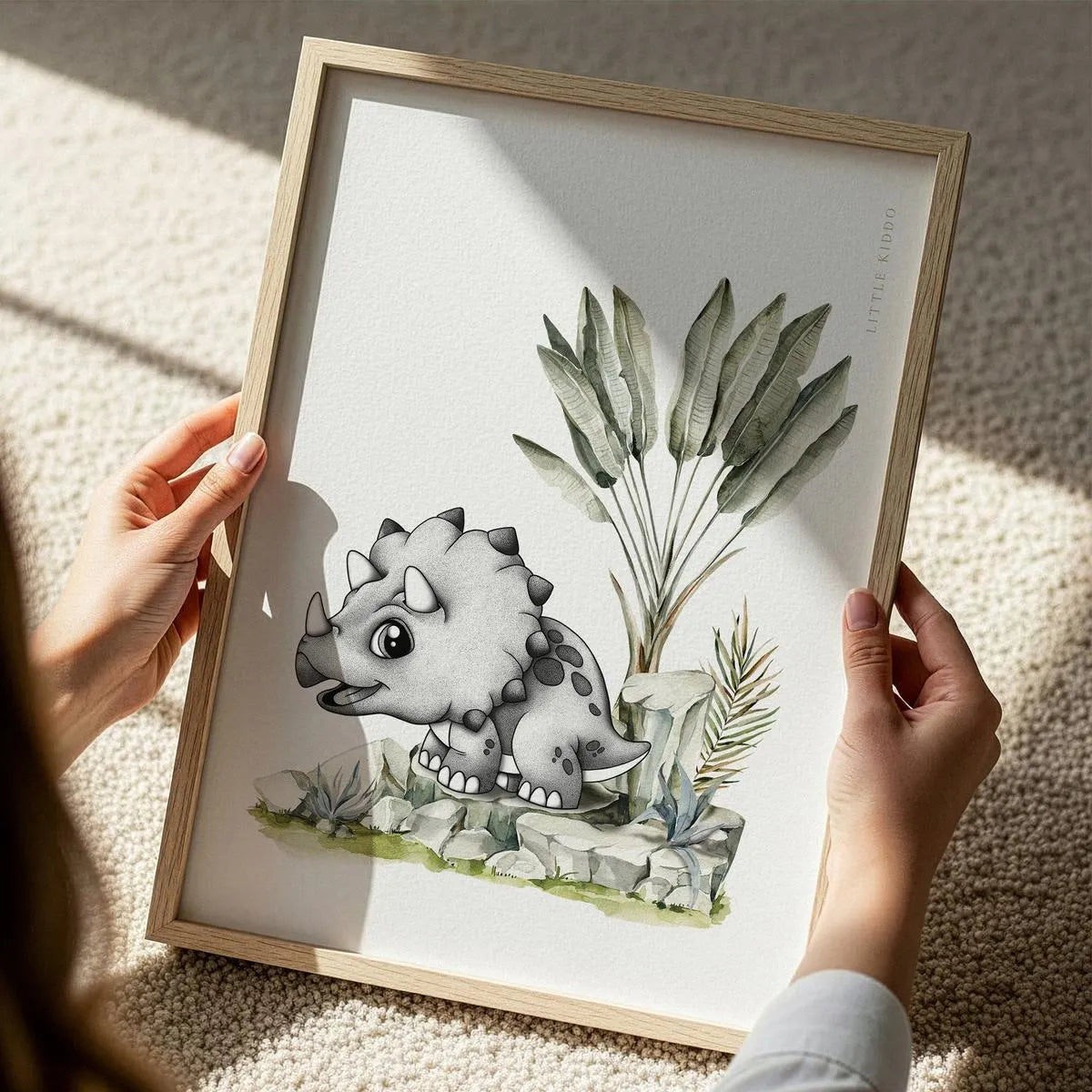Close-up of a hand-inked Triceratops illustration for a kids' room, featuring detailed stippling and soft green watercolor plants.